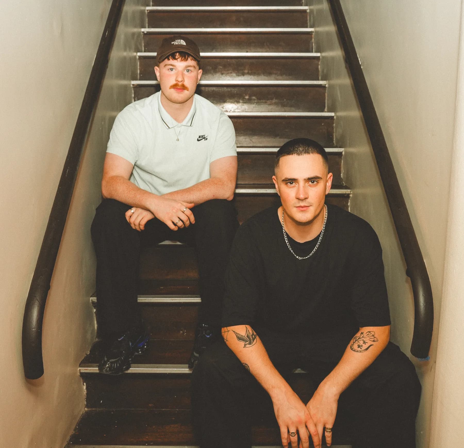 Sam Knight and Oisin Cullen, owners of Runaway Club, seated on a stairwell